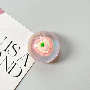 Close-up of iridescent heart phone grip with pink core and floral detail in resin