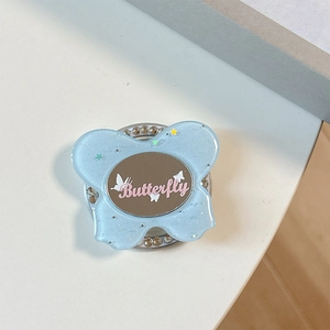 Close-up of blue glittery butterfly phone grip with sparkling rhinestones and mirror