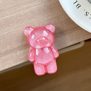 Close-up of a pink glitter bear phone grip with sparkling resin and glossy finish