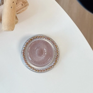 Nahaufnahme einer rosa Glitzer-Handyhalterung mit einem Ring aus champagnerfarbenen Perlen