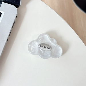 Detailed macro of glitter 3D cloud phone grip with handmade text on silver metal piece