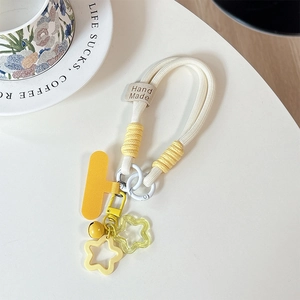 Detail of woven phone strap with yellow star charms and handmade leather label