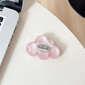 Pink glitter cloud phone grip with silver handmade plate on a white desk