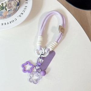 Handwoven taro purple phone lanyard with star charms and bell detail on white background