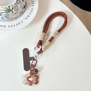 Detail of dark brown braided phone lanyard with bell, metal clasp and flower charms