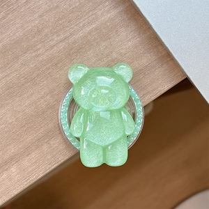 Detail of mint green translucent bear phone grip with glitter finish and pearl accents