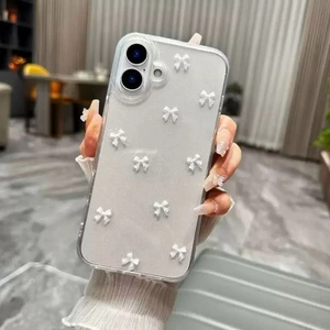 Close-up of clear phone case with 3D white bows on a hand-held smartphone