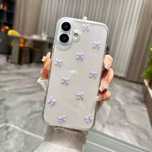 Close-up of clear glitter phone case featuring 3D purple bows on a handheld device