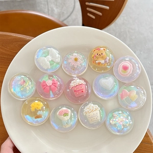 Iridescent laser crystal ball phone socket with cute resin charms on a white plate