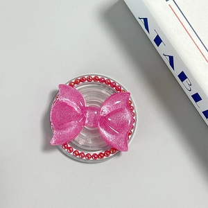 Detailed view of pink glitter bow MagSafe phone socket with red beads and transparent base