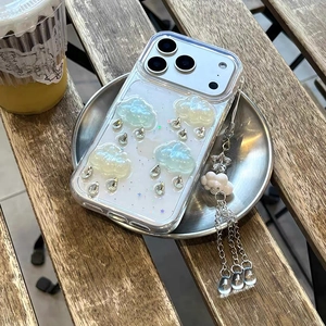 Close-up of clear iPhone case featuring 3D resin clouds, aurora glitter, and drop pendant