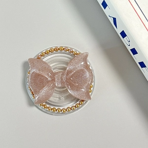 Detail of rose gold glitter bow phone grip with golden bead border and magnetic base