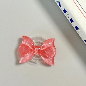 Detailed view of pink glitter bow MagSafe magnetic phone grip with retractable base