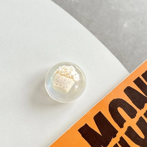 Close-up of a 3D popcorn bucket miniature inside a transparent resin phone griptok