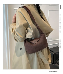 Detail of vintage brown suede crescent shoulder bag with silver buckle and leather strap