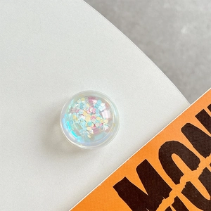 Macro shot of circular phone grip featuring iridescent colorful sequins inside resin