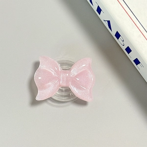 Close-up of pink glitter bow phone grip featuring Magsafe suction and resin texture