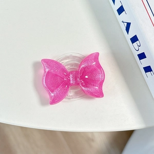 Close-up of a pink glitter bow MagSafe phone grip with a sparkling resin finish