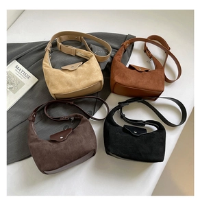 Close-up of suede half-moon hobo bags in beige, camel, coffee and black colors