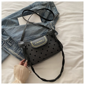 Gros plan d'un sac à bandoulière rétro à pois avec sangle tissée sur fond minimaliste