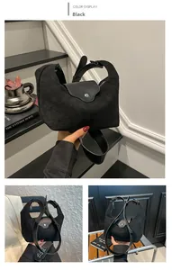 Detail of minimalist black suede tote bag with leather flap and silver metallic snap button