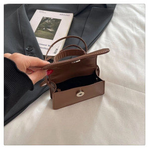 Close-up of brown faux leather mini bag featuring a silver magnetic snap closure