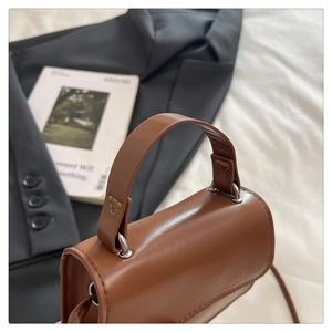 Detailed macro view of the caramel brown leather bag with silver metal ring hardware