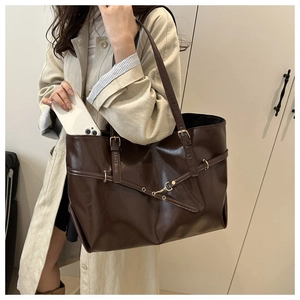 Detail of dark brown tote bag showing adjustable straps and large capacity for daily use