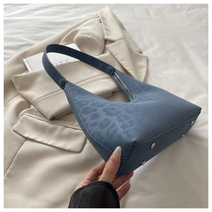 Detail of blue leopard pattern tote bag with silver studs and premium leather texture