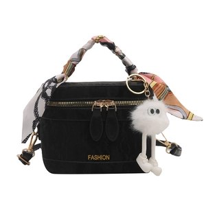 Fashionable black velvet handbag with silk scarf handle and plush doll keychain