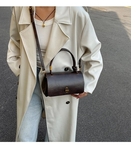 Detail of vintage dark brown wrinkled leather bag with gold buckle and shoulder strap