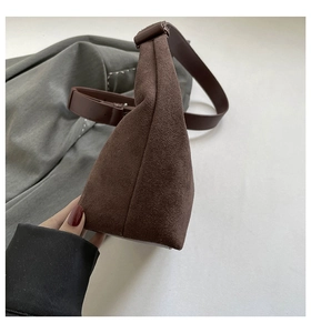 Detailed side view of deep brown suede shoulder bag with adjustable leather strap