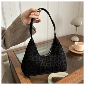 Detailaufnahme der Leopardenmuster-Tasche auf Holztisch mit gemütlicher Atmosphäre