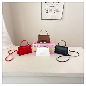 Detailed display of mini crossbody bags with scalloped flap edges in four classic colors