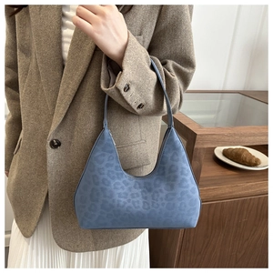 Makroaufnahme von blauem Wildleder mit Leopardenmuster und Prägung auf der Hobo-Tasche