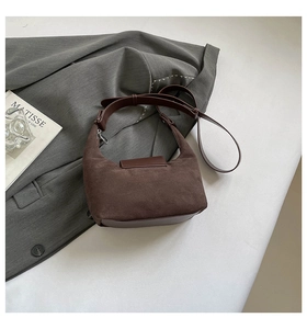 Close-up of vintage brown suede shoulder bag with high-quality leather stitching detail