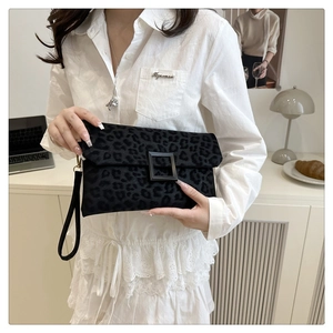 Detail of black leopard print suede clutch with matte square buckle and wristlet strap