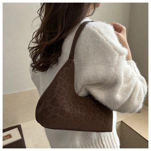 Dunkelbraune Hobo-Tasche mit Leopardenmuster auf Model in minimalistischem Raum