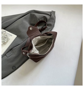 Detail view of the vintage brown shoulder bag showing internal pockets and lining