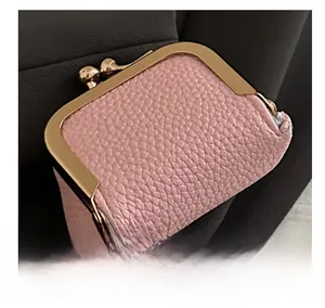 Macro view of pink pebble grain leather jewelry pouch with gold kiss-lock closure