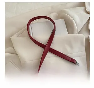 Detail of the dual-strap design featuring wine red leather and silver chain on shoulder bag
