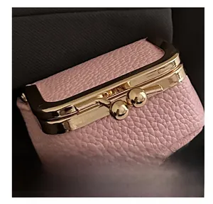 Detail of pink lychee leather mini jewelry pouch with vintage gold metal clasp closure