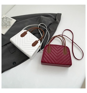 Detail of white and burgundy V-quilted small square bags with brown top handles