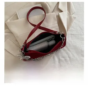 Internal view of red shoulder bag showing capacity for phone, lipstick and spray