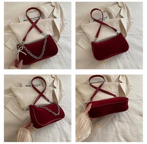 Detail view of burgundy velvet shoulder bag showing silver chain and rhinestone bow charm