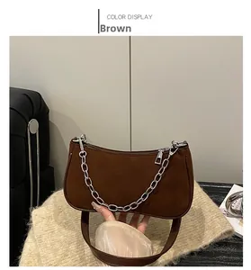 Close-up of matte coffee brown crescent shoulder bag with silver chunky chain accent