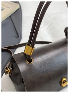 Detail shot of vintage dark brown leather texture and elegant golden metal lock hardware
