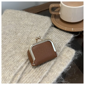 Close-up of brown litchi grain leather mini purse with elegant gold kiss-lock clasp