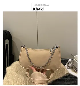Detail of khaki suede hobo bag with silver chain accessory and long leather shoulder strap