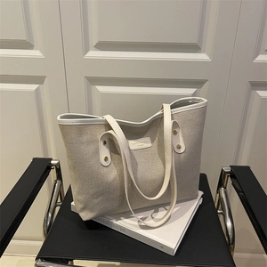 Fashionable color-block canvas tote bag with leather trim on a stylish chair